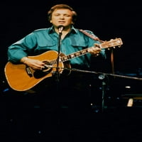Дон Маклийн, който се изпълнява в концерт, свирейки на китарен плакат